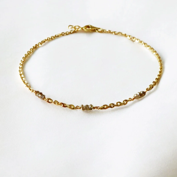 Armbånd i 14 kt. guld og 3 x 3 facetterede diamanter.